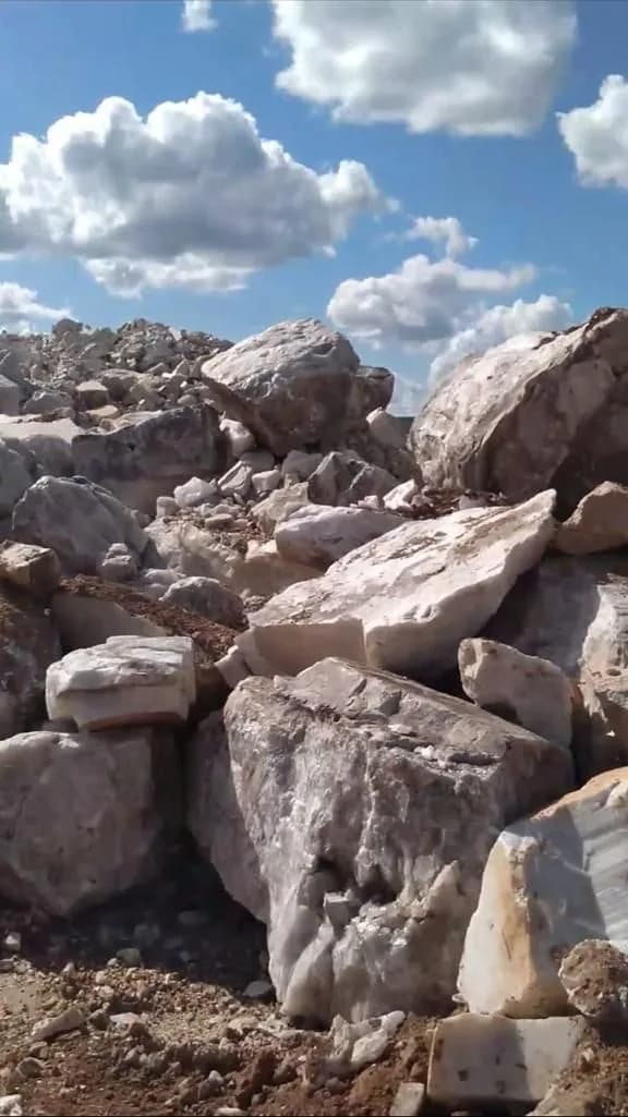 Campo de blocos de quartzo branco acumulados na frente de lavra